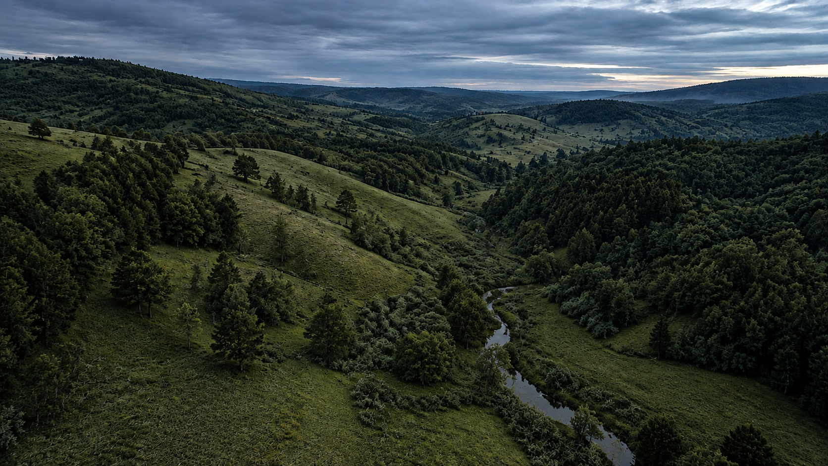 Rolling green acreage and a winding creek beneath a slate-blue morning sky